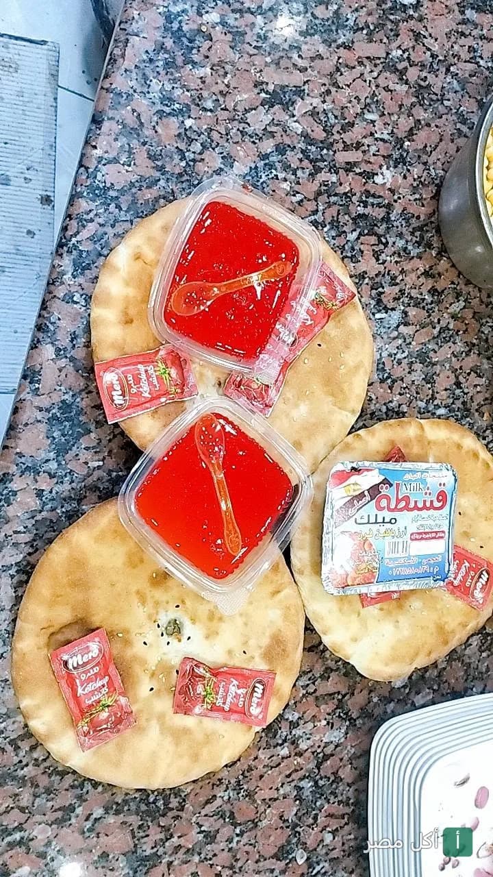 أرغفة خبز طازجة مع علب صوص أحمر وأكياس كاتشب في مطعم نجوم التحرير ببرج العرب.