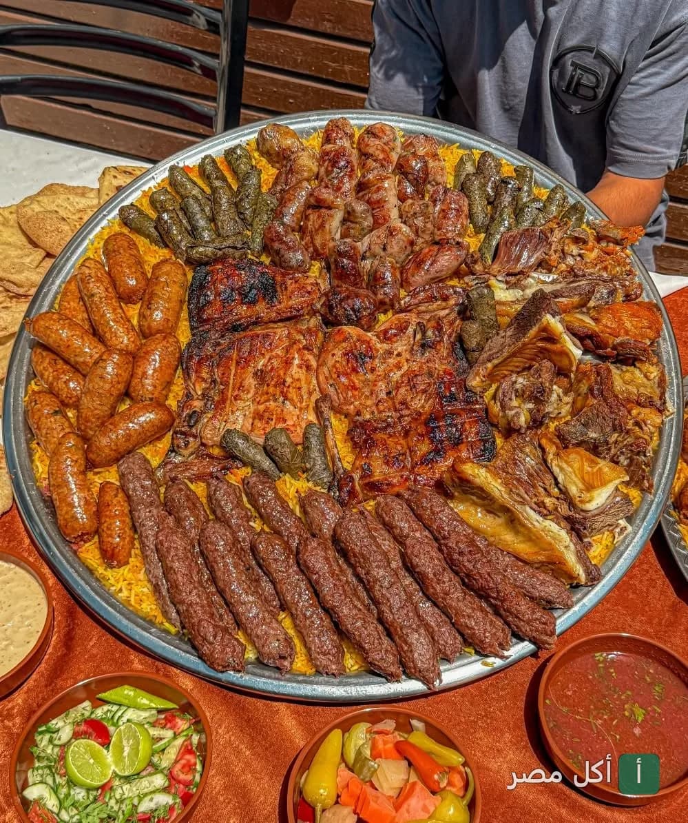 صينية مشويات شرقية كبيرة من مطعم حضرموت في كرموز، تضم كباب وكفتة ودجاج ومحشي ورق عنب مع أطباق جانبية.