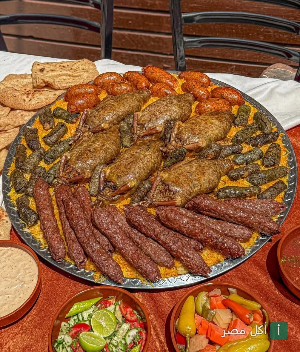 صينية مشويات شرقية كبيرة من مطعم حضرموت بكرموز، تضم حمام محشي وكفتة وسجق وورق عنب على أرز، مع مقبلات وسلطات.