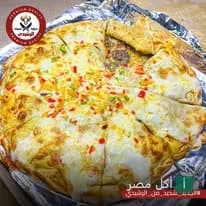 بيتزا مقطعة ومغطاة بالجبنة والفلفل الملون من مطعم الرشيدي في مينا البصل.