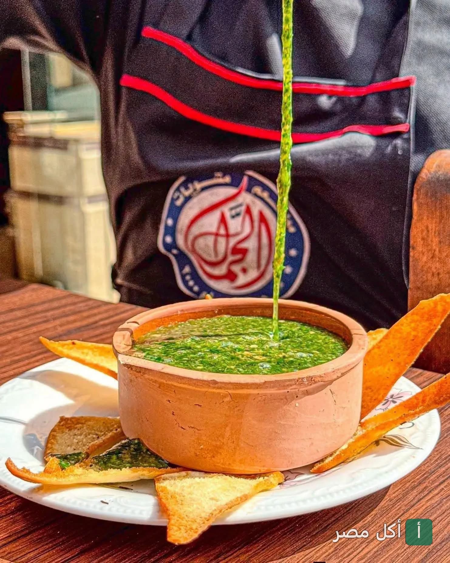 طاجن ملوخية ساخن يُصب في مطعم مشويات الجمّال بمينا البصل في الإسكندرية.