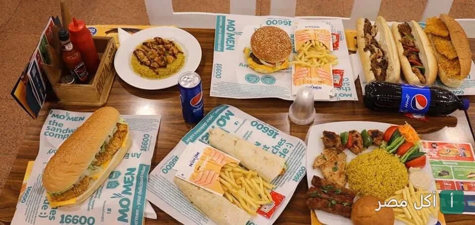 تشكيلة متنوعة من ساندوتشات ووجبات مطعم مؤمن في مينا البصل، تشمل البرجر، المشويات، والبطاطس المقلية.