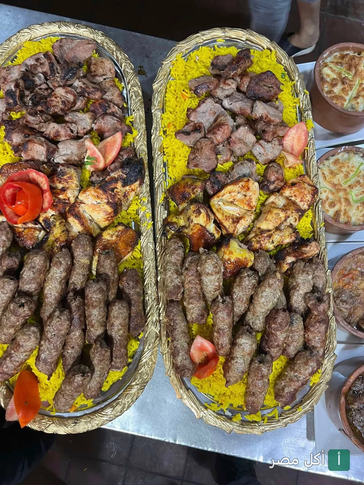 صواني مشويات متنوعة تضم كباب وكفتة وشيش طاووق على أرز أصفر في مطعم قلعة المشويات بمينا البصل.