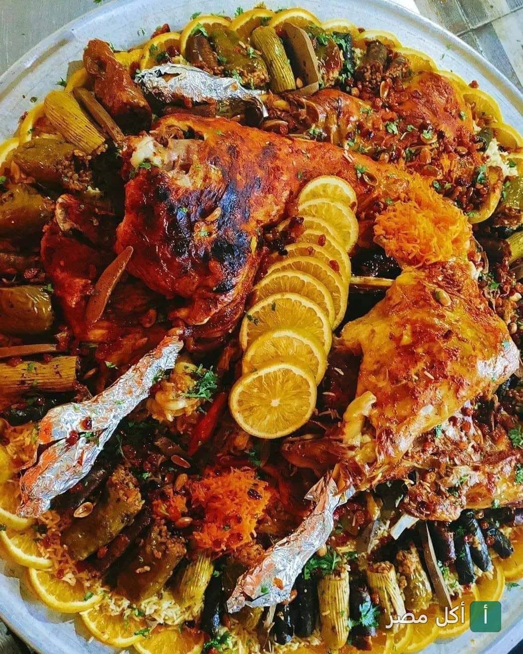 صينية مشاوي كبيرة من مطعم قلعة المشويات بمينا البصل، تحتوي على لحم محمر ومحاشي مزينة بشرائح الليمون.