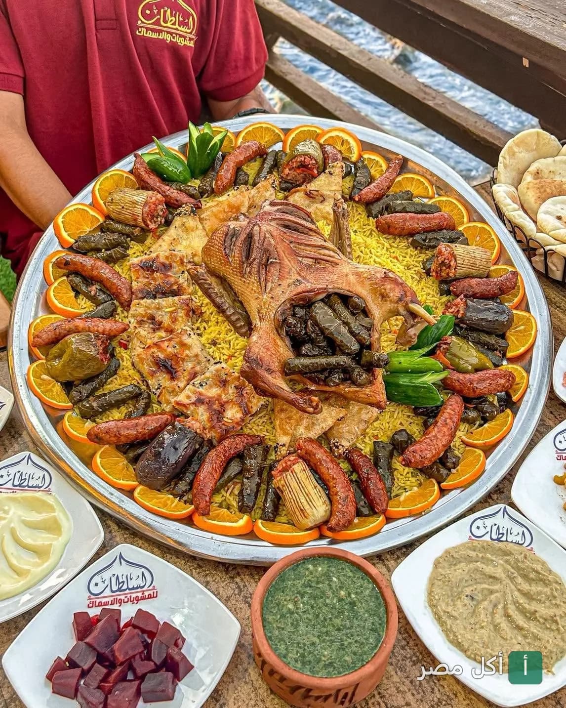 صينية كبيرة من مطعم السلطان بالورديان تحتوي على بط محشو ورق عنب وأرز ومشاوي مع مقبلات جانبية.