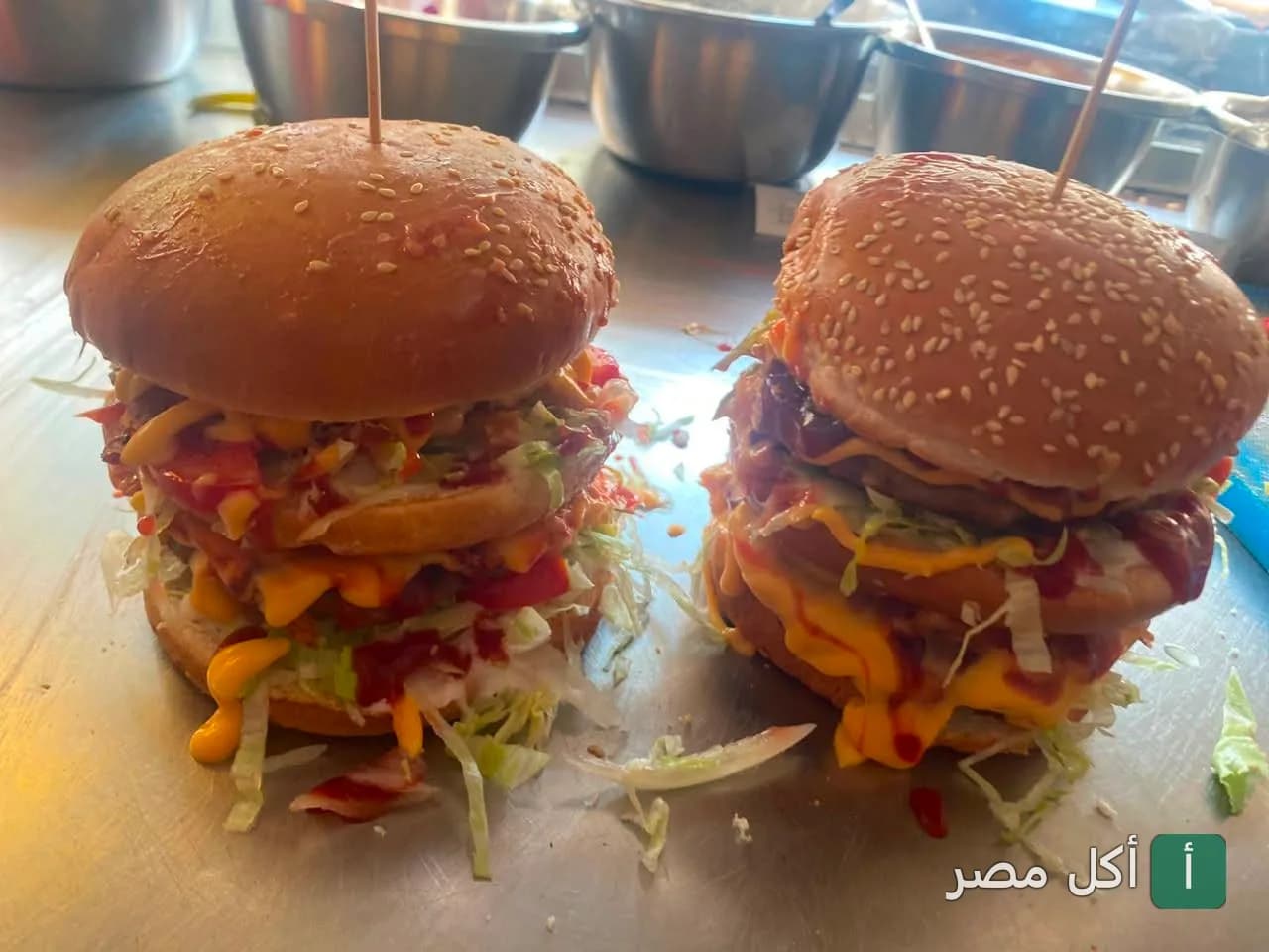 ساندوتشات برجر مزدوجة الطبقات مع صوص الجبنة والكاتشب في مطعم كشرى على جحا بمينا البصل.