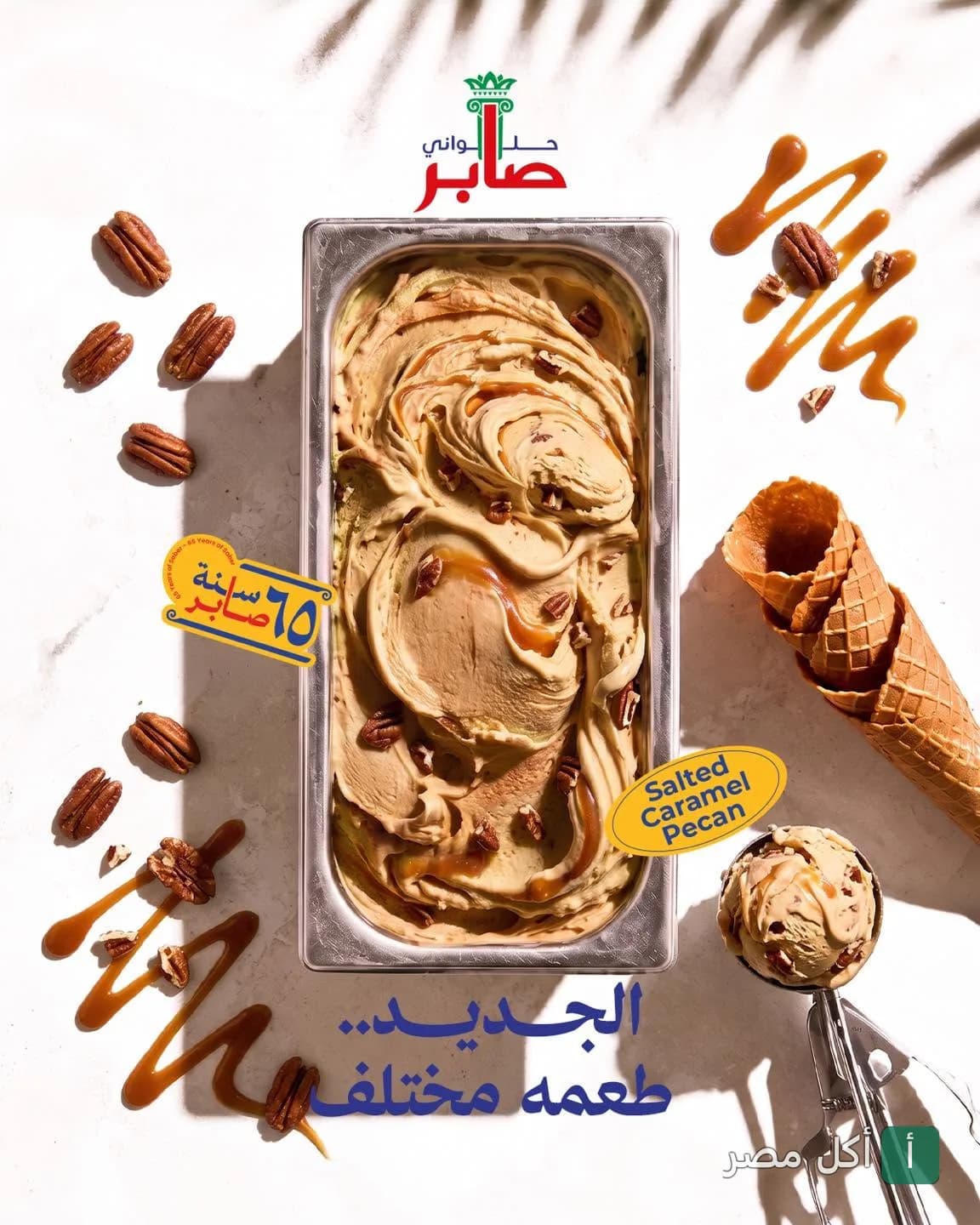 آيس كريم كراميل مملح بالبيكان من حلواني صابر في علبة معدنية مع بسكويت وافل ومكسرات بيكان.