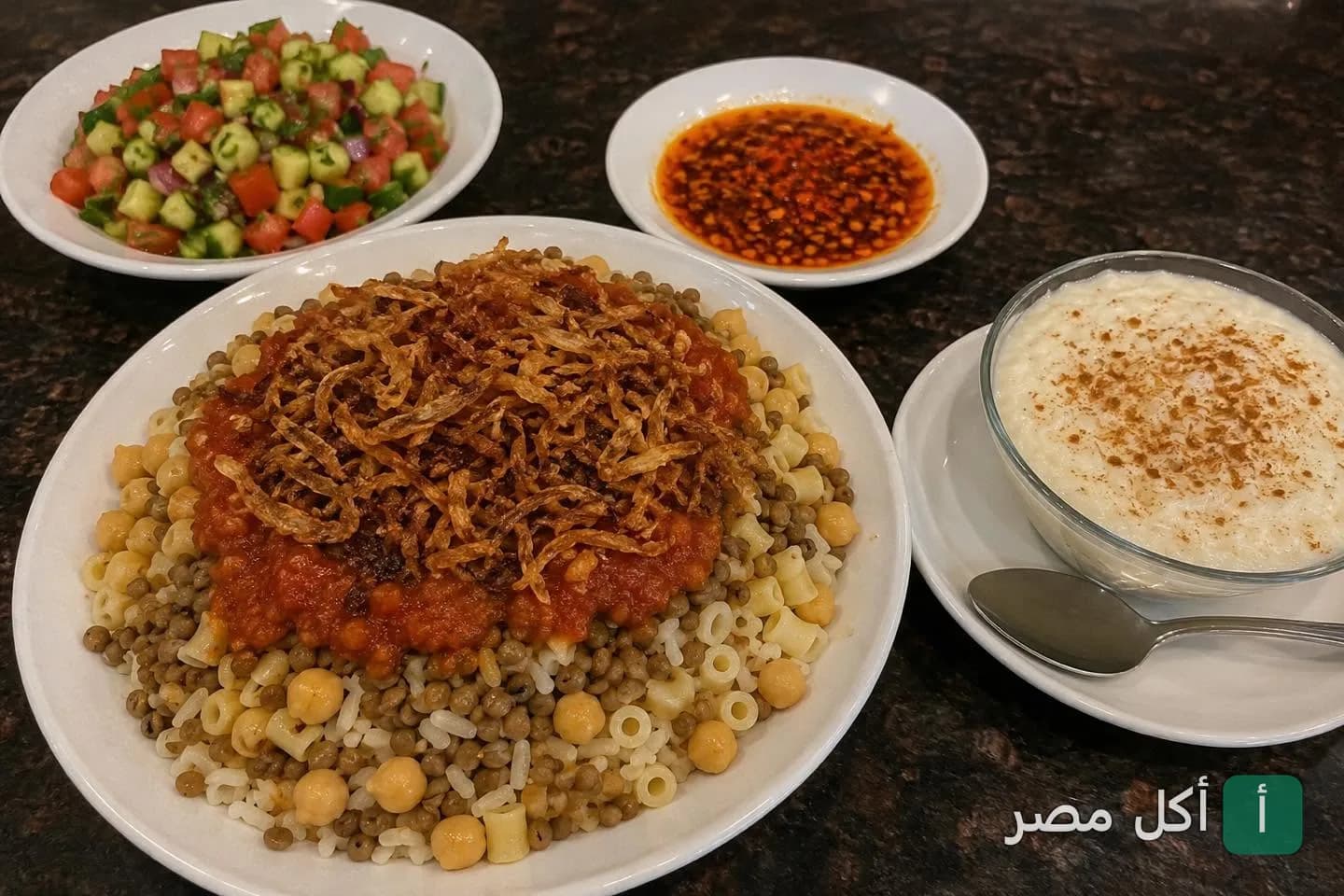 طبق كشري مصري مع صلصة وشطة وسلطة وأرز بلبن من كشري عزوز في مينا البصل