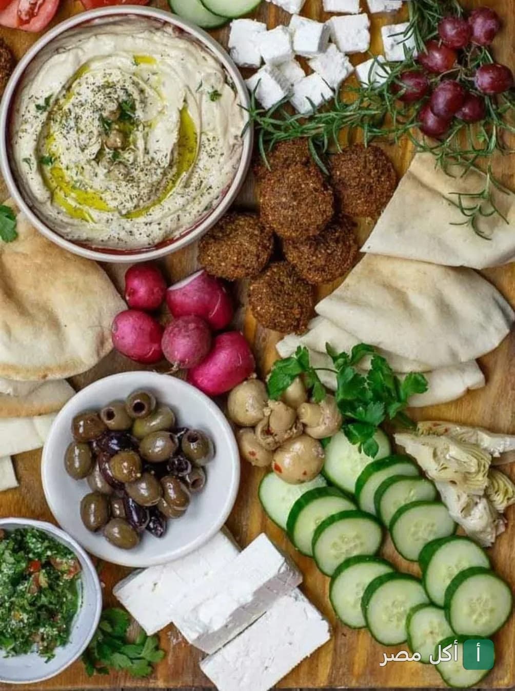 طبق فطور مصري متنوع يضم طعمية، جبنة بيضاء، حمص، زيتون، وخضروات طازجة في كافيه سلطنة المتراس بمينا البصل.