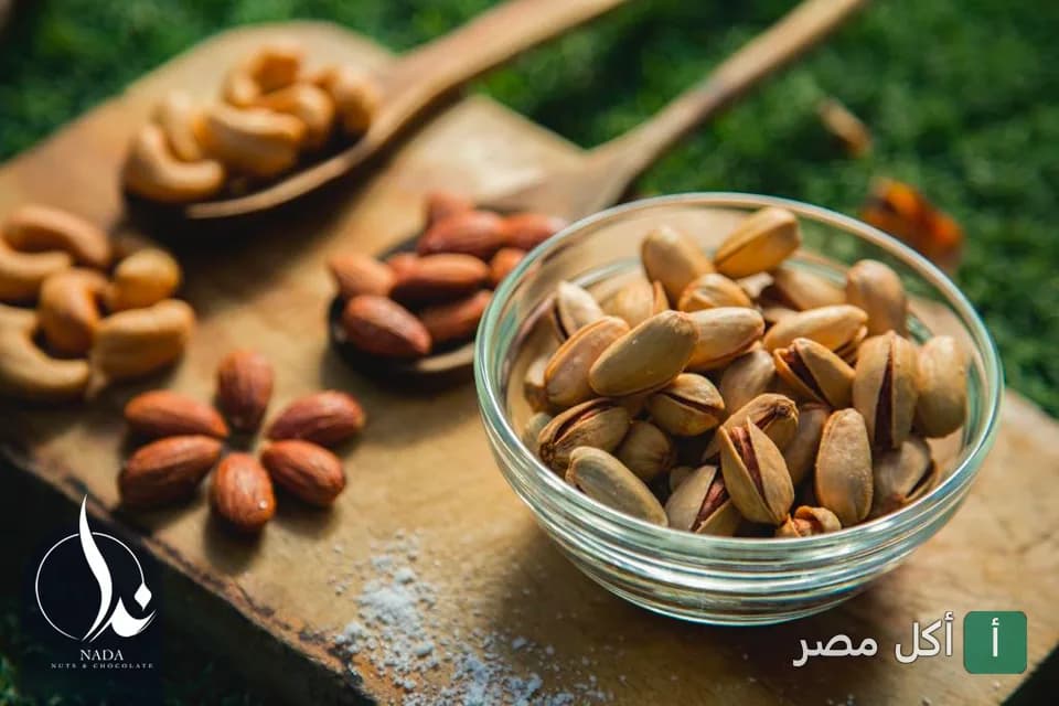 طبق من الفستق والمكسرات المتنوعة على لوح خشبي في كافيه دوار ندا بمينا البصل.