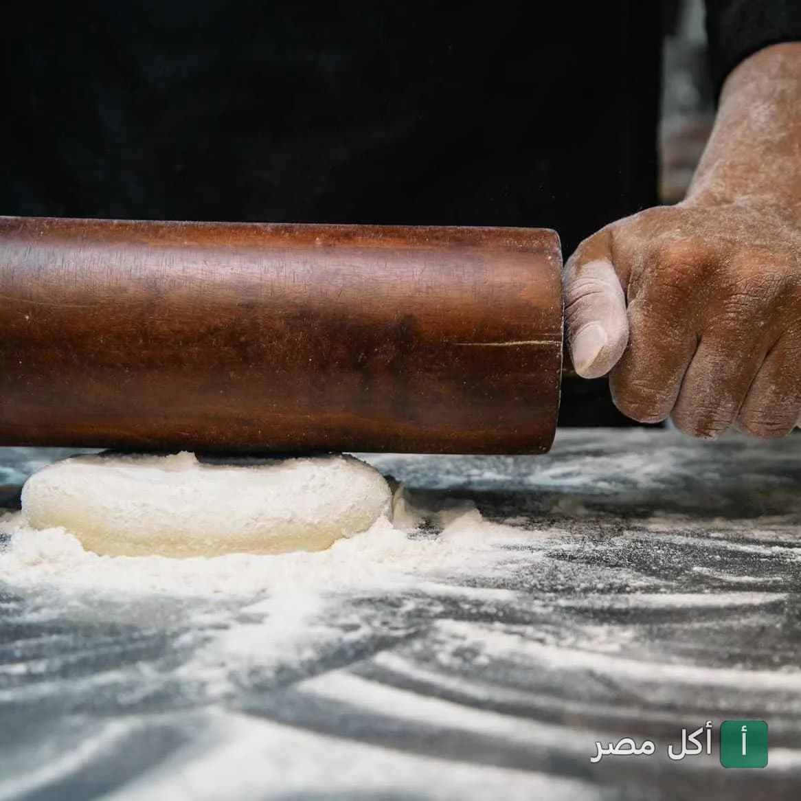طاهٍ يستخدم النشابة لفرد العجين على سطح مرشوش بالدقيق في كافية باب الحارة بالإسكندرية.