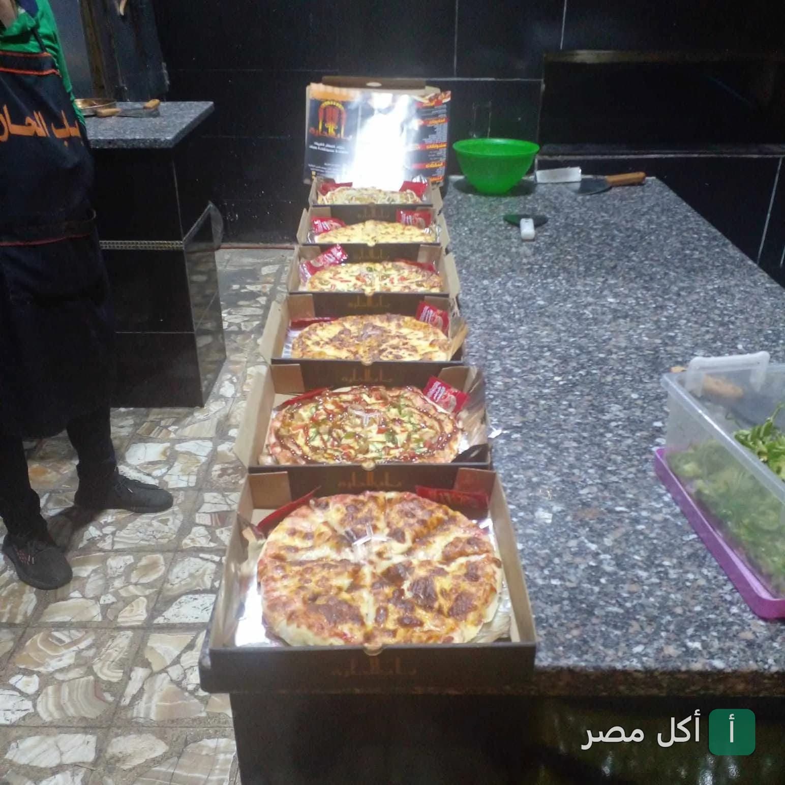 مجموعة بيتزا طازجة في كرتون التغليف داخل مطبخ كافية باب الحارة في مينا البصل بالإسكندرية.