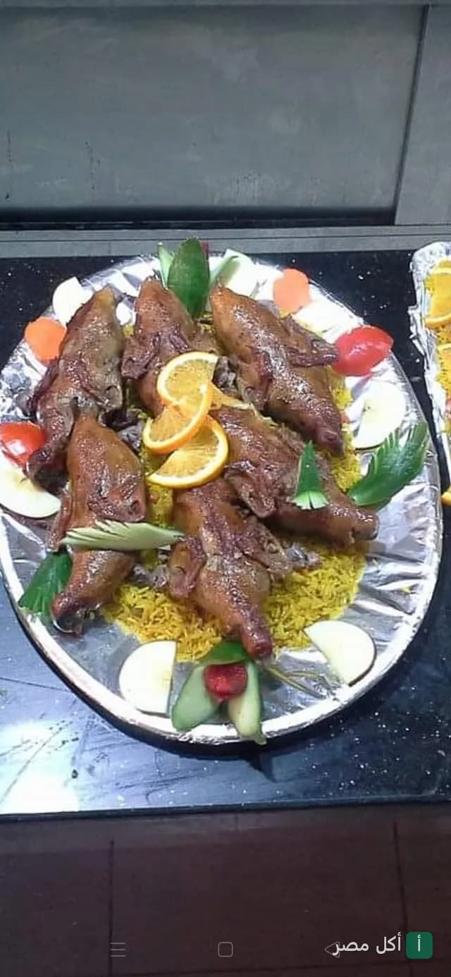 طبق بط محمر مع أرز أصفر مزين بشرائح البرتقال والخضروات في مطعم الريف المصري بسيدي بشر.