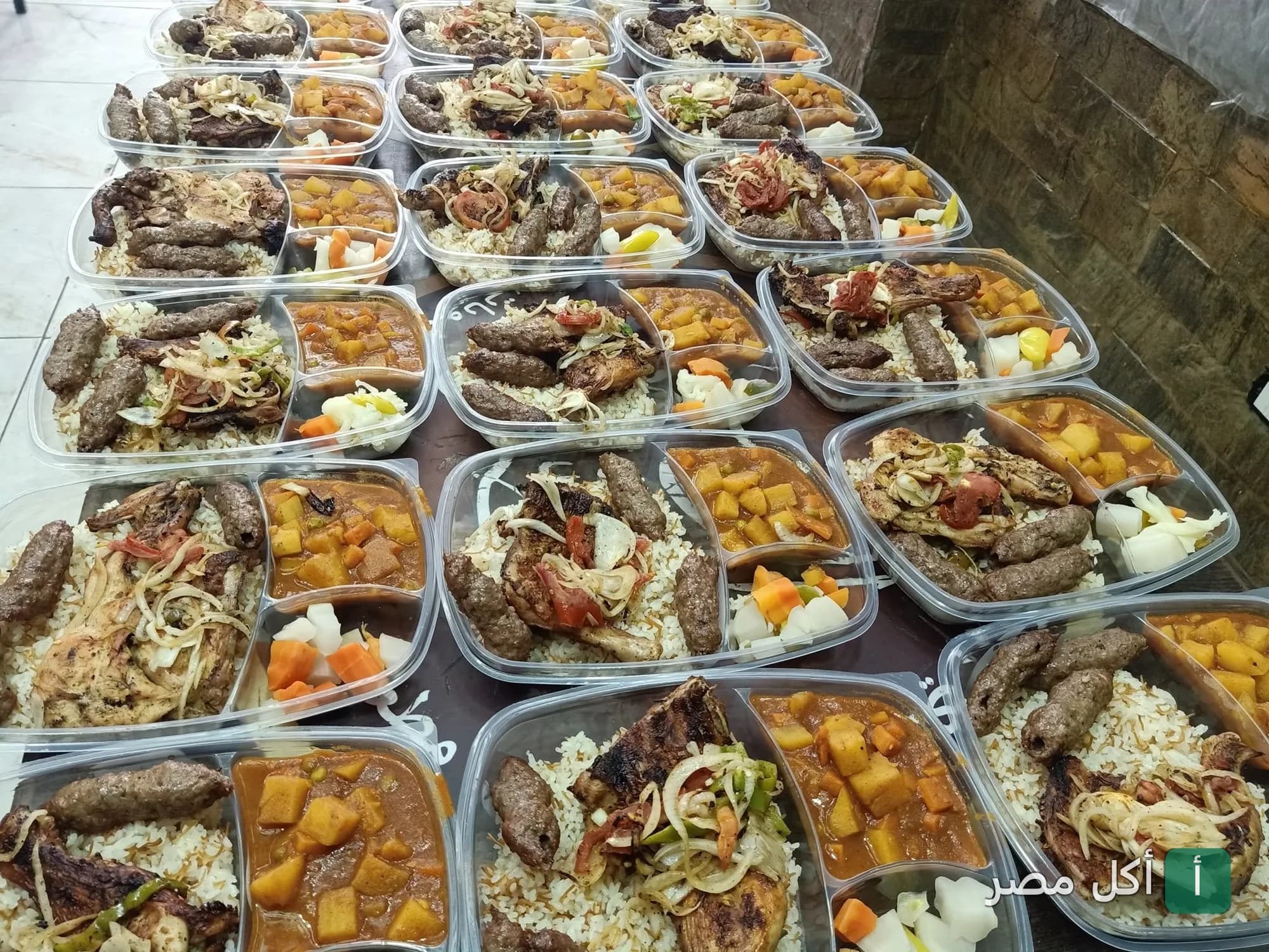 وجبات جاهزة من مطعم الريف المصري في سيدي بشر تضم مشويات وأرز وخضار.