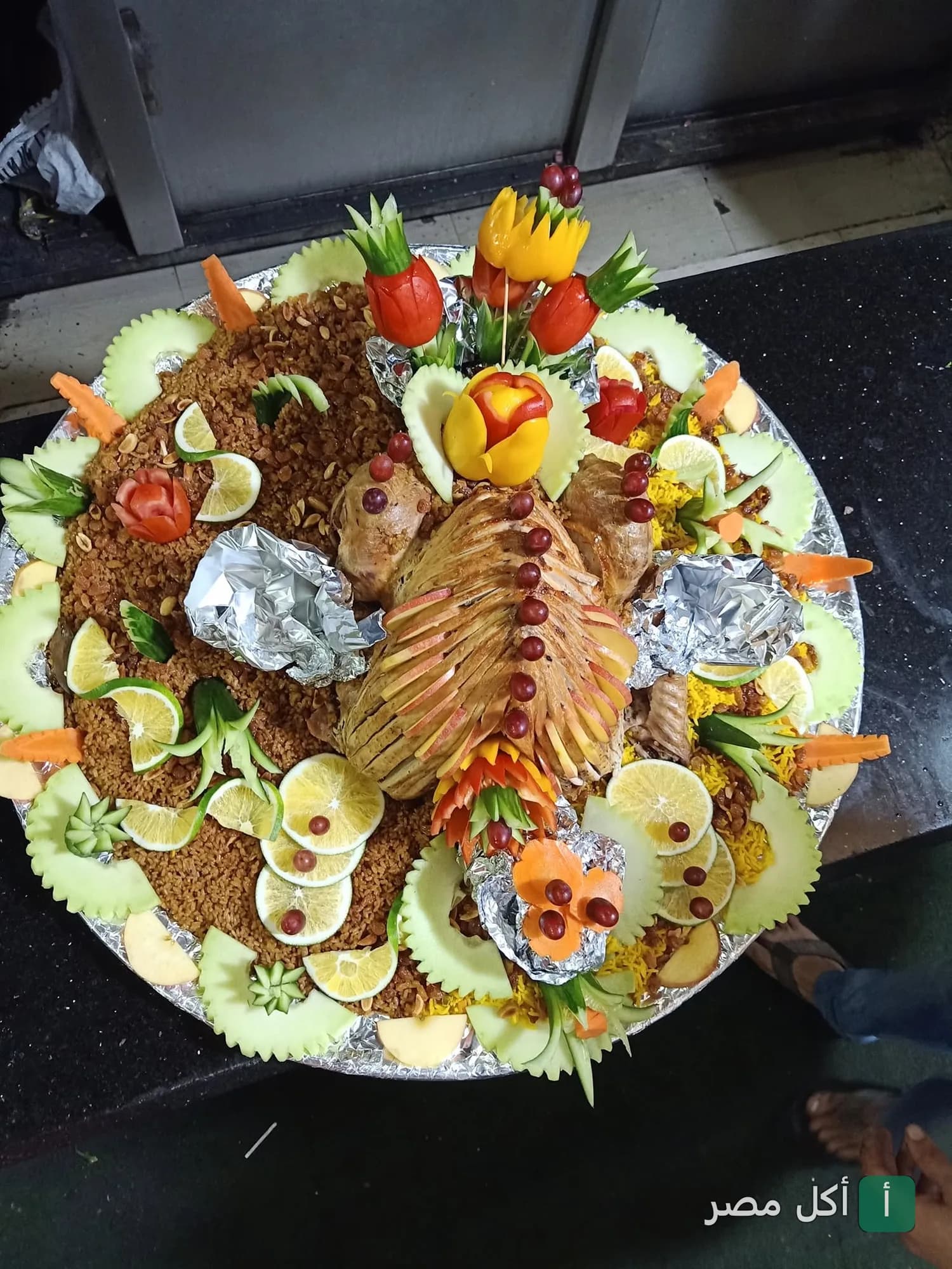 طبق كبير من الأرز المزين بالدواجن والفواكه المقطعة في مطعم الريف المصري بسيدي بشر بحري.